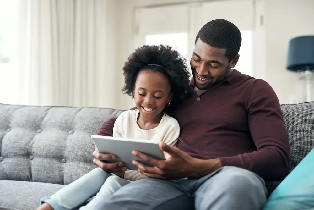 father and daughter watching a show on ipad